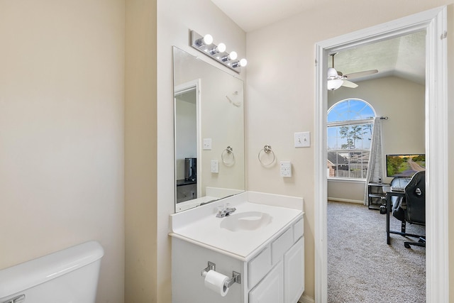 bathroom featuring a ceiling fan, toilet, vanity, and vaulted ceiling