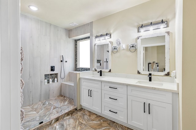 full bath with double vanity, a walk in shower, marble finish floor, and a sink