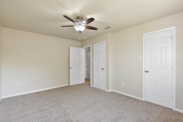 unfurnished bedroom featuring a ceiling fan, carpet, visible vents, and baseboards