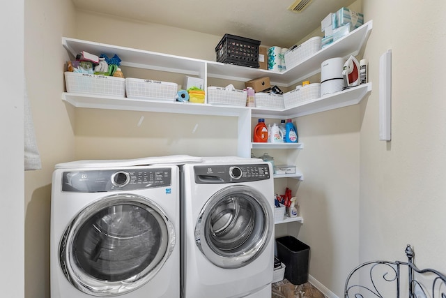 washroom featuring baseboards, independent washer and dryer, and laundry area