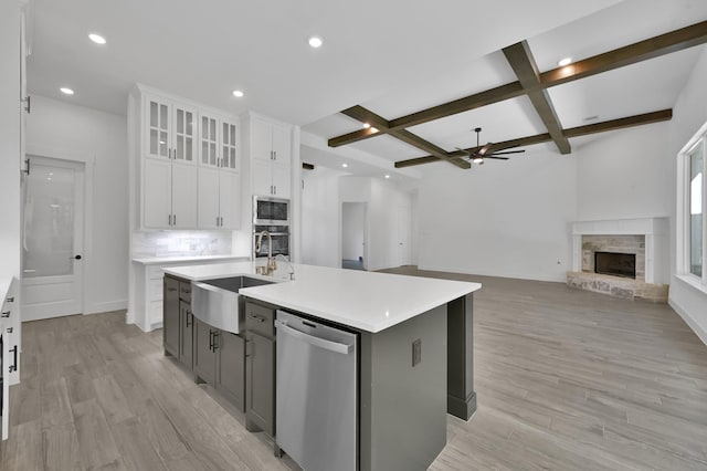 kitchen featuring a sink, coffered ceiling, stainless steel appliances, light wood finished floors, and ceiling fan