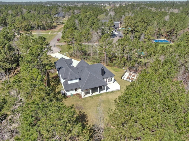 drone / aerial view with a wooded view