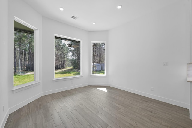 unfurnished room featuring recessed lighting, visible vents, baseboards, and wood finished floors