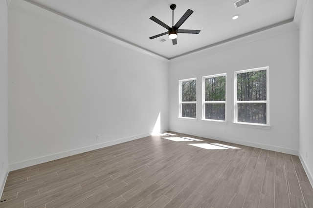 spare room with visible vents, a ceiling fan, baseboards, and wood finished floors