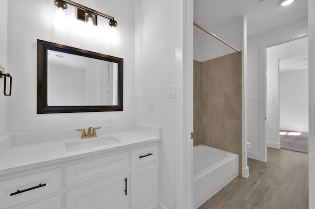 bathroom featuring vanity, toilet, wood finished floors, and tub / shower combination