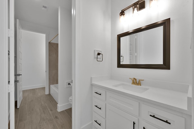 bathroom with vanity, wood finished floors, visible vents, tub / shower combination, and toilet