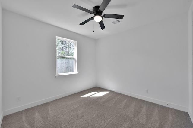 spare room featuring a ceiling fan, carpet, visible vents, and baseboards