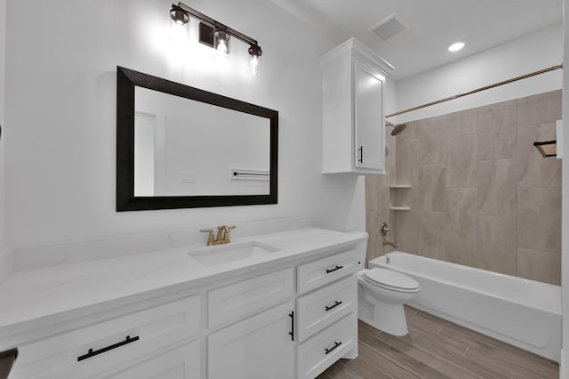 full bath featuring vanity, visible vents, wood tiled floor, shower / tub combination, and toilet