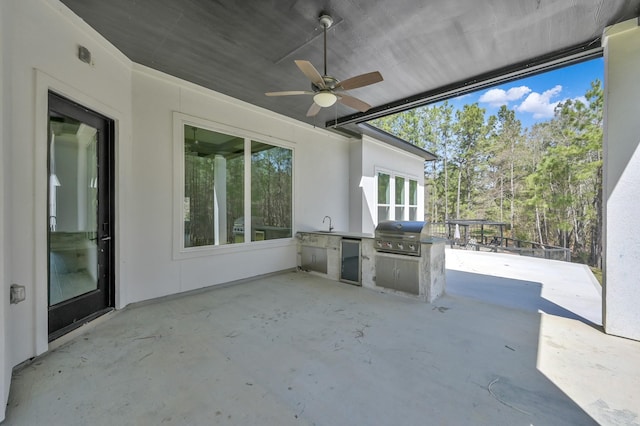 view of patio / terrace featuring ceiling fan, grilling area, an outdoor kitchen, and a sink