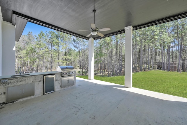 view of patio / terrace featuring a sink, area for grilling, a ceiling fan, and an outdoor kitchen