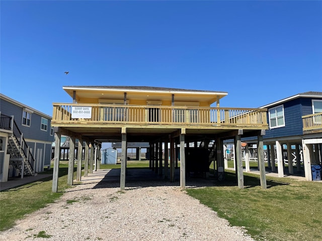 exterior space with a carport, stairway, a front yard, and dirt driveway