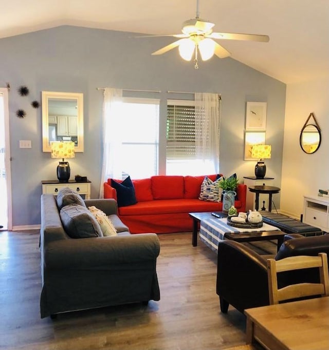 living area featuring baseboards, wood finished floors, ceiling fan, and vaulted ceiling