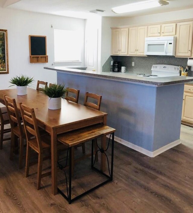 kitchen featuring dark wood finished floors, electric range, white microwave, and tasteful backsplash