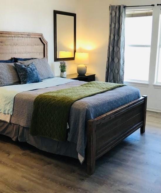 bedroom featuring multiple windows and wood finished floors