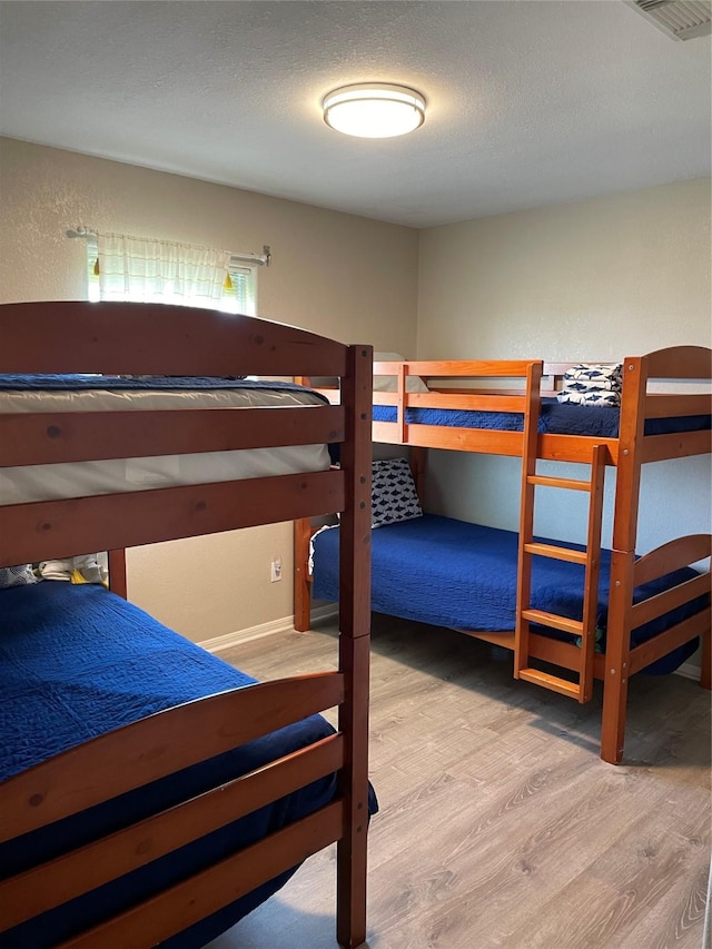 106 Coconut Rd, Surfside Beach, TX 77541 - bedroom featuring wood finished floors, visible vents, and a textured ceiling
