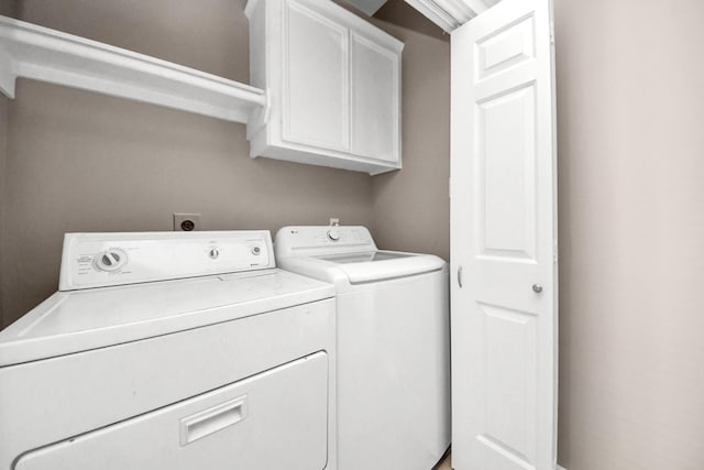 laundry area with cabinet space and separate washer and dryer