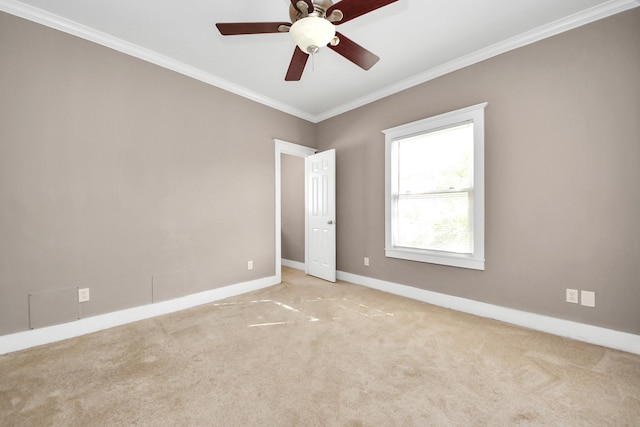 carpeted spare room with baseboards, ornamental molding, and a ceiling fan