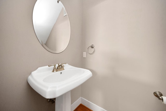 bathroom featuring baseboards and a sink