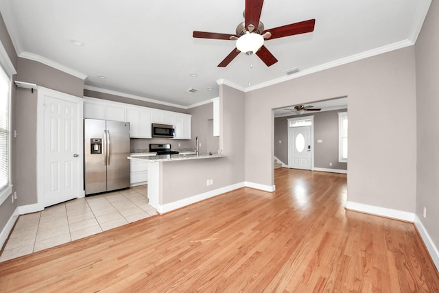 kitchen featuring visible vents, light wood-type flooring, stainless steel appliances, white cabinetry, and a ceiling fan