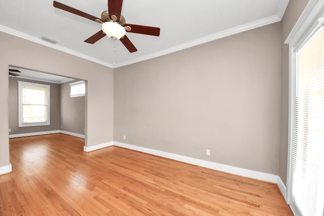 unfurnished room featuring ceiling fan, light wood-style floors, baseboards, and ornamental molding