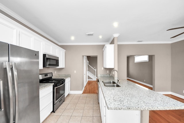 kitchen with a ceiling fan, visible vents, a peninsula, a sink, and appliances with stainless steel finishes