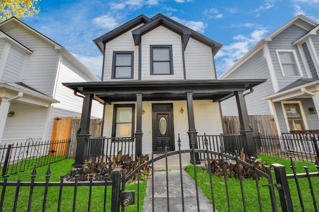 view of front of house with a fenced front yard, a porch, and a front lawn