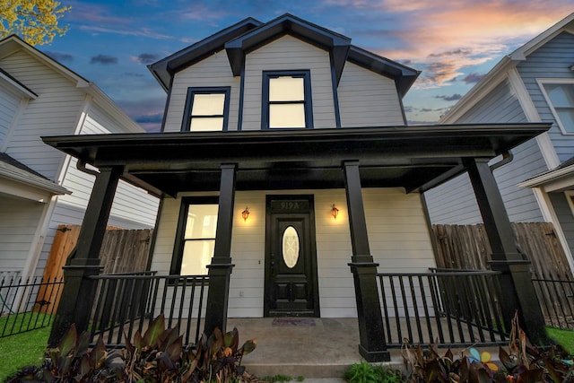 view of front of property with covered porch and fence