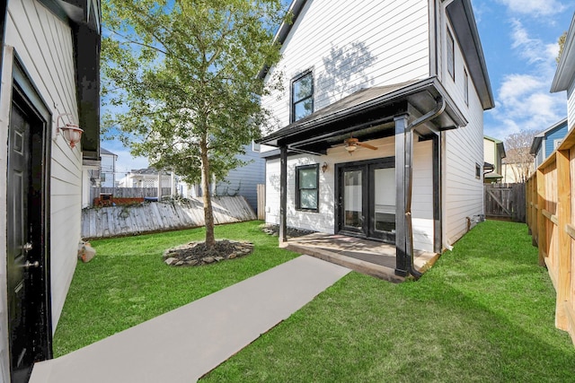 back of property featuring a yard, a fenced backyard, a patio area, and ceiling fan