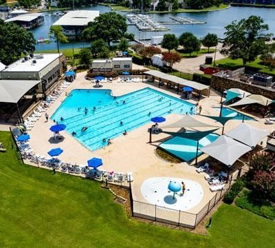 pool with a patio, a lawn, and a water view