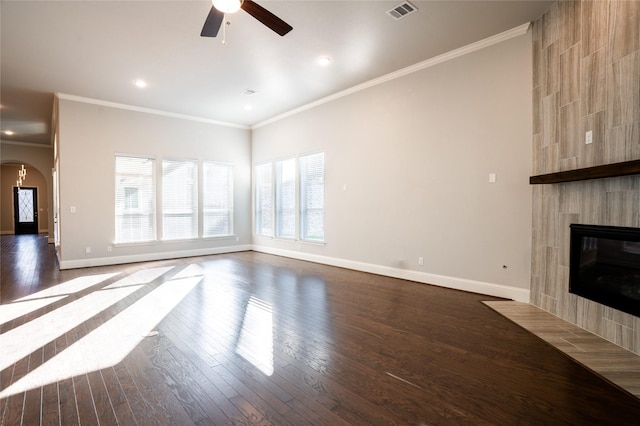 unfurnished living room featuring visible vents, crown molding, baseboards, ceiling fan, and dark wood-style floors