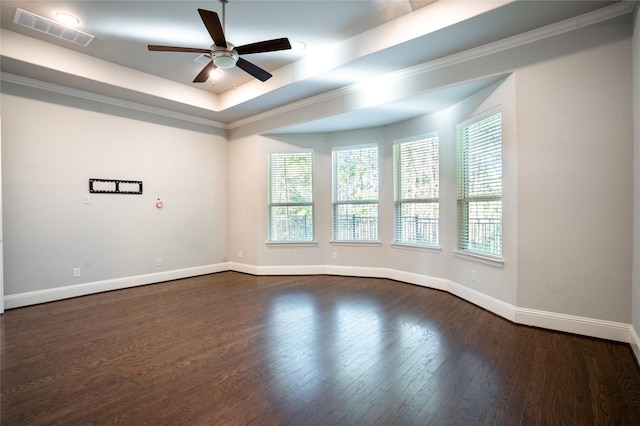 empty room featuring baseboards, visible vents, ceiling fan, dark wood-type flooring, and a raised ceiling