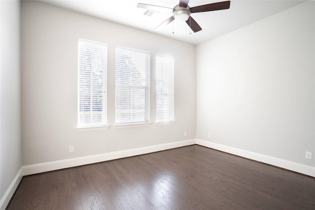 unfurnished room with visible vents, baseboards, dark wood-style flooring, and ceiling fan