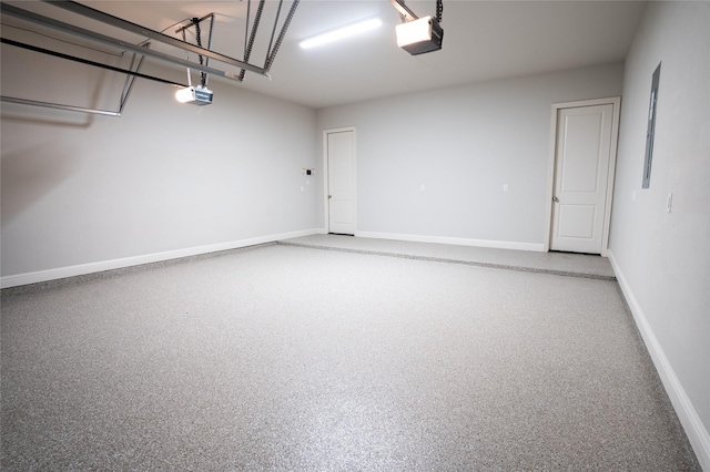 garage featuring a garage door opener and baseboards