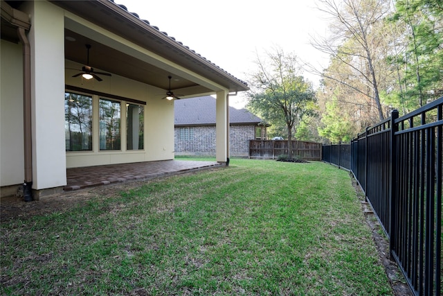 view of yard with a fenced backyard, a ceiling fan, and a patio area