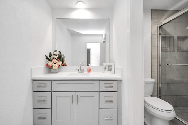 bathroom featuring vanity, toilet, and a stall shower