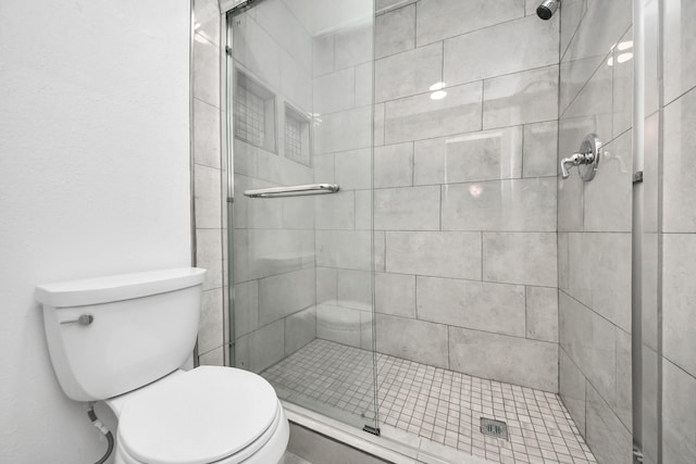 bathroom with a shower stall and toilet