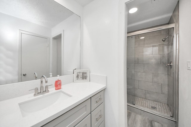 full bath with a stall shower and vanity