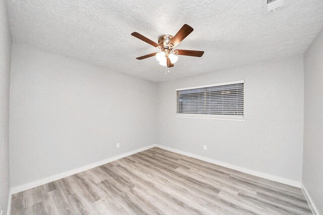 unfurnished room with visible vents, ceiling fan, baseboards, light wood-style floors, and a textured ceiling