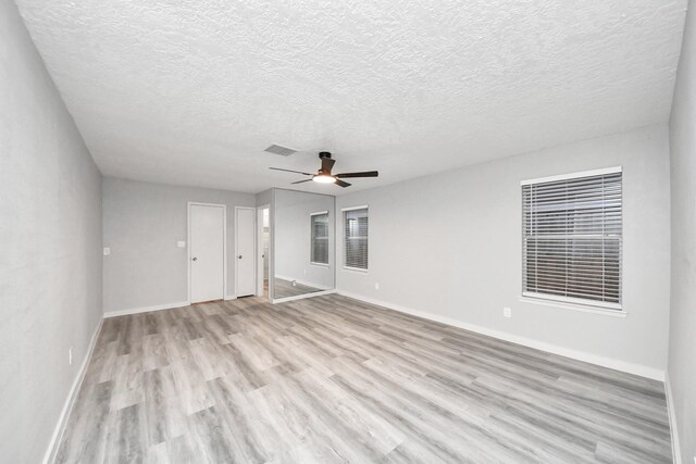 empty room with light wood finished floors, visible vents, baseboards, and ceiling fan