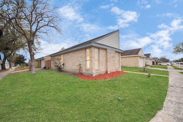 view of side of property with a garage, a lawn, and brick siding