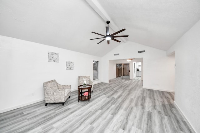 living area featuring beamed ceiling, baseboards, ceiling fan, and wood finished floors