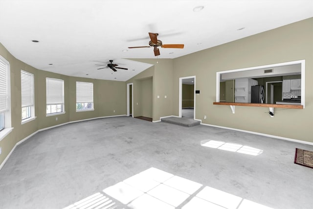 unfurnished living room featuring visible vents, baseboards, vaulted ceiling, carpet flooring, and a ceiling fan