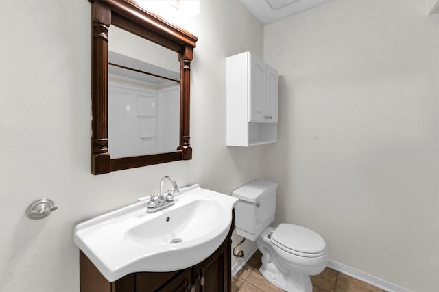 bathroom with tile patterned floors, toilet, vanity, and baseboards