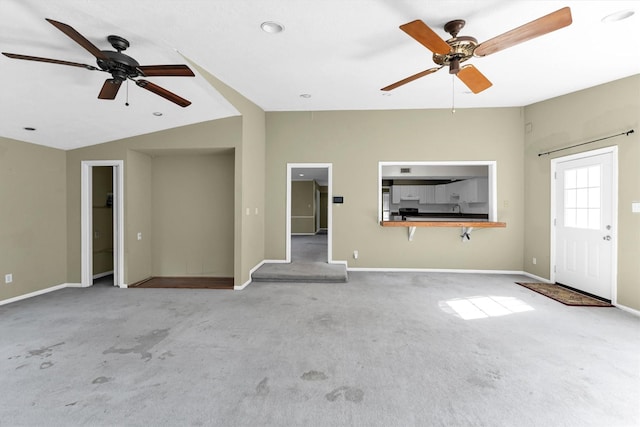 unfurnished living room with vaulted ceiling, carpet, baseboards, and ceiling fan