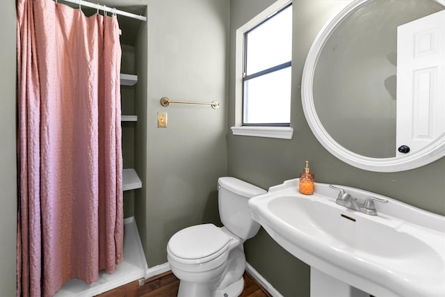 full bath featuring a shower with curtain, toilet, a sink, wood finished floors, and baseboards