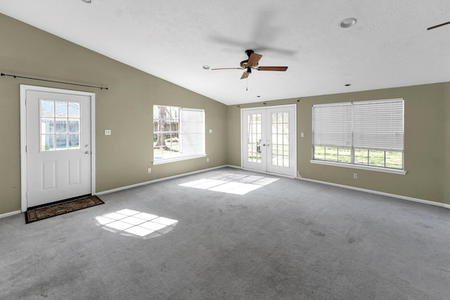 unfurnished living room featuring plenty of natural light, french doors, lofted ceiling, and ceiling fan