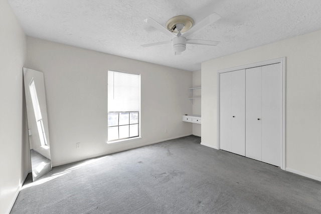 unfurnished bedroom featuring ceiling fan, carpet, a closet, and a textured ceiling