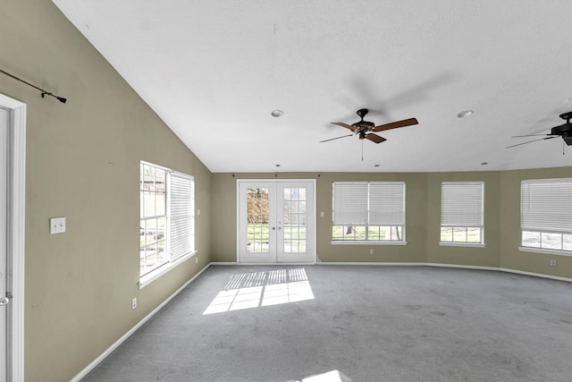 carpeted empty room with plenty of natural light, a ceiling fan, baseboards, and french doors