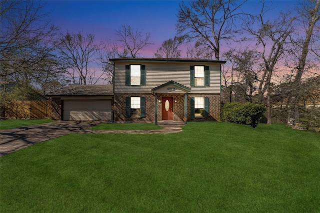 view of front facade with fence, driveway, an attached garage, a front lawn, and brick siding