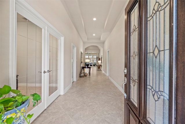 entrance foyer featuring recessed lighting, french doors, arched walkways, light tile patterned floors, and baseboards